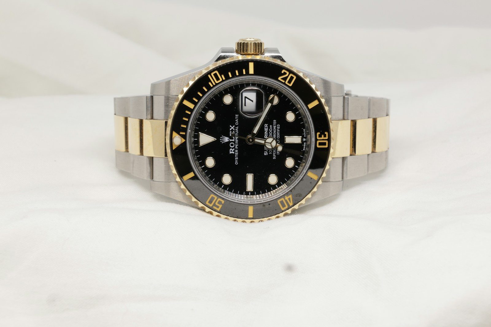 a black and gold rolex watch on a white background